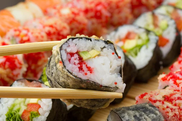 Rollo de sushi caliente o caliente Takusen con tobiko rojo tempura y aguacate —  Fotos de Stock