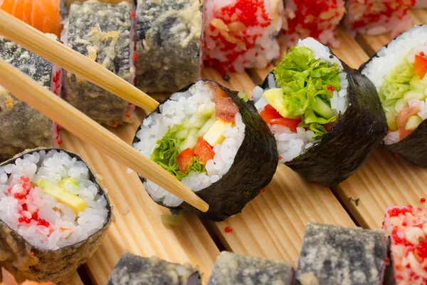 Rollo de sushi vegetariano con platos hechos de rollos de sushi sobre fondo — Foto de Stock