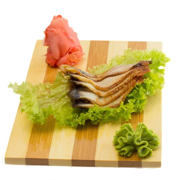 Pedaços de peixe de enguia em placa de madeira isolada — Fotografia de Stock