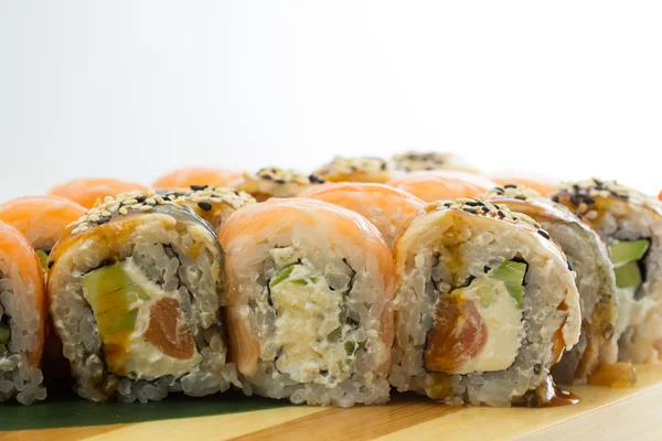 Rollos de sushi en placa de madera — Foto de Stock