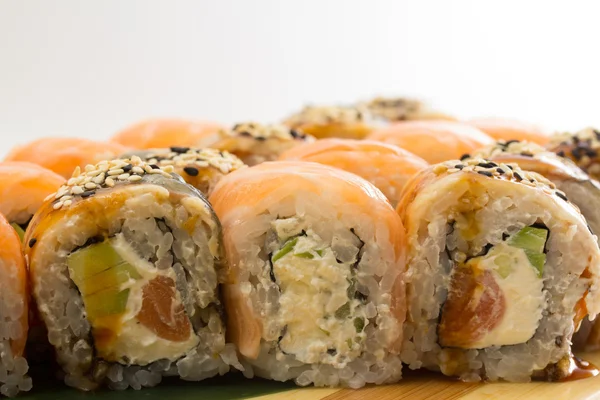 Rollos de sushi en placa de madera — Foto de Stock