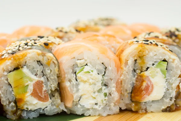 Rolos de sushi em placa de madeira — Fotografia de Stock