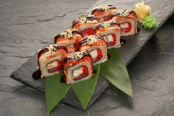 Sushi bułki z tuńczyka węgorz unagi i awokado na czarnym kamiennym talerzu. — Zdjęcie stockowe