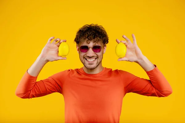 Retrato Jovem Óculos Segurando Limões Ambas Mãos Sobre Fundo Amarelo — Fotografia de Stock