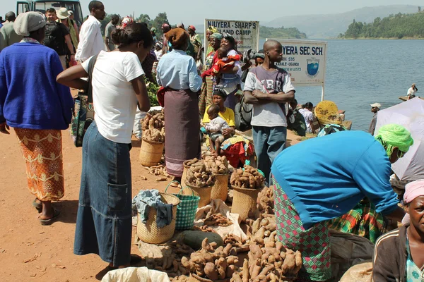 African woman buys sweet potatoes. — Stock Photo, Image