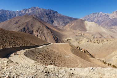 Muktinath Sadak. Traktör dağ yolunda yol boyunca sürüyor. Himalayalar 'da Jomsom' dan Muktinath 'a çakıl yolu.