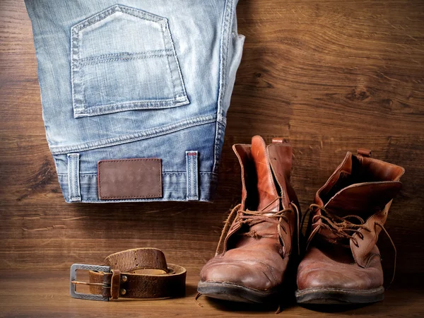 Une paire de vieilles bottes, un jean et une ceinture en cuir — Photo