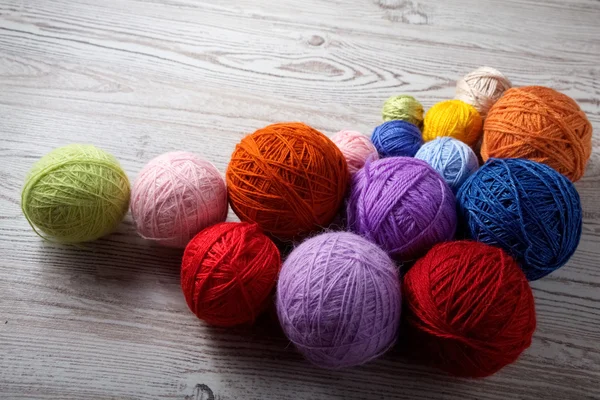 Kleurrijke ballen van garen op een houten tafel — Stockfoto