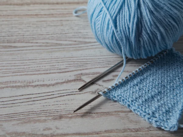 Balle de fil et tricot sur une table en bois — Photo