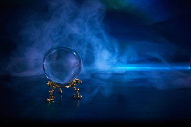 Koyu mavi dumanlı arka planda kristal küre. Geleceğe yönelik tahminler.