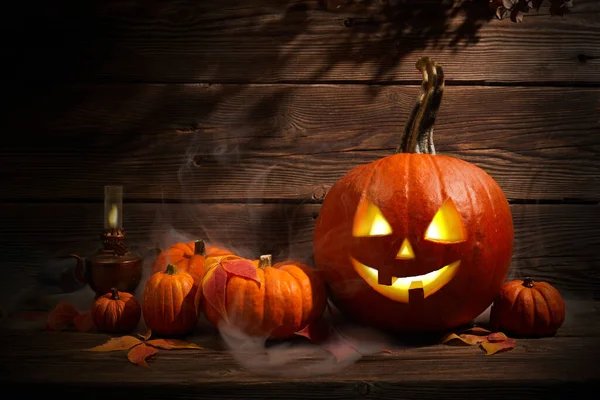 Halloween citrouille tête Jack lanterne avec de la fumée sur fond de bois sombre — Photo