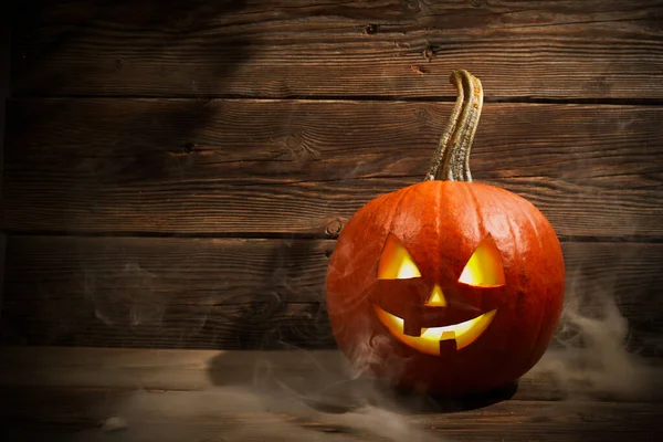 Halloween citrouille tête Jack lanterne avec de la fumée sur fond de bois sombre — Photo