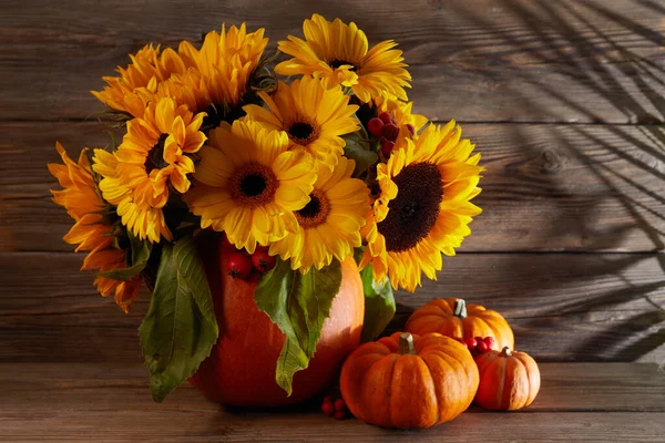 Composizione di fiori autunnali in un vaso di zucca con zucche su sfondo di legno — Foto Stock