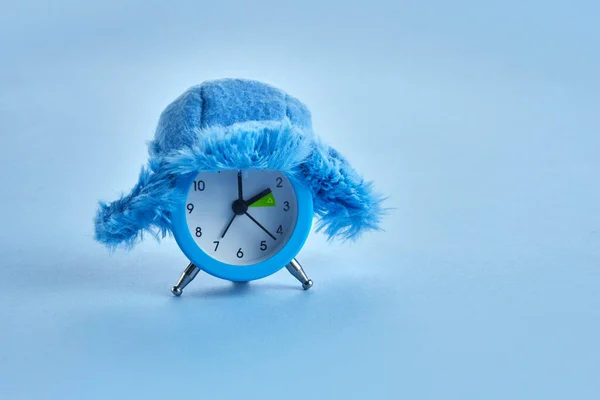 Clock changing from summer to winter time. Alarm clock with winter hat — Stock Photo, Image