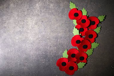 Dünya Savaşı 'nı anma günü. Kırmızı haşhaş savaşta ölenleri anmanın sembolüdür. Koyu taşlı arka planda kırmızı kağıt gelincikleri