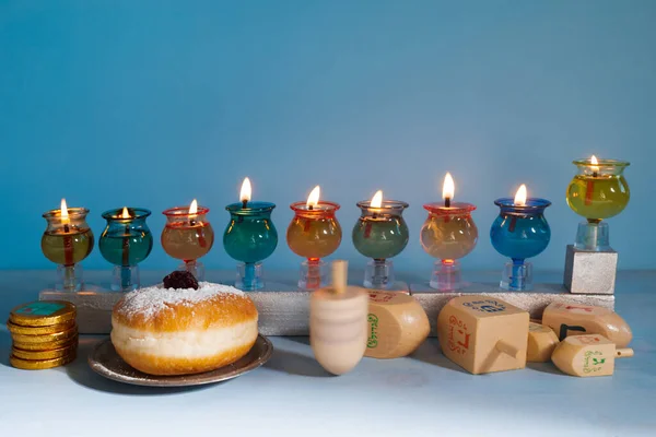 유대 명절 하누카의 배경은 오일 메노라 - 전통적 인 촛대, 드 렉델 과 두그 넛의 꼭대기를 푸른 배경으로 — 스톡 사진