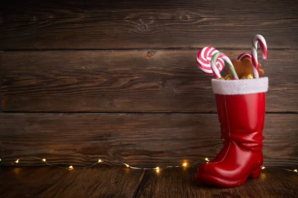 Mikołajowe buty ze słodyczami i prezentami na Dzień Świętego Mikołaja 6 grudnia. — Zdjęcie stockowe