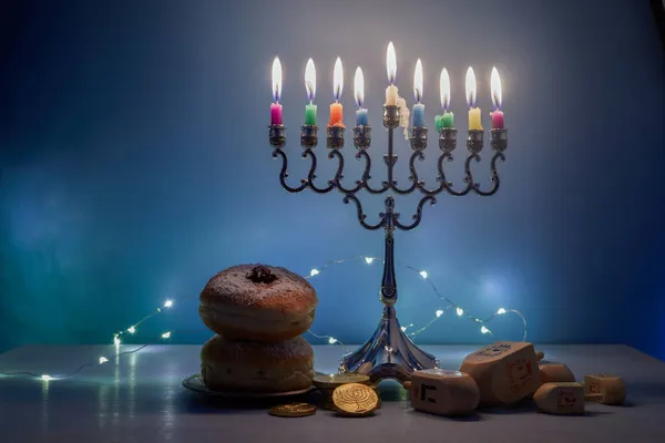 Fiesta judía fondo Hanukkah con Menorah tradicional candelabro, peonza Dreidel y Donut sobre fondo azul — Foto de Stock