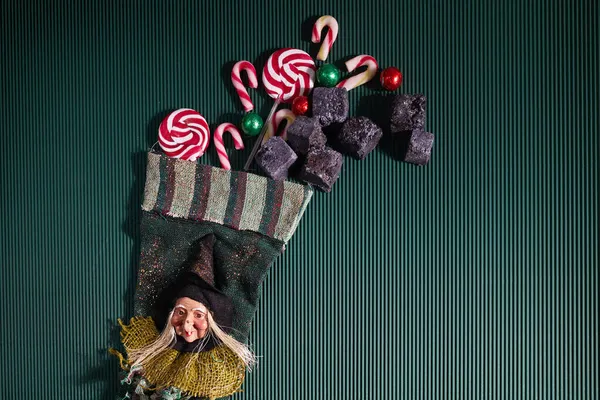 Befana sock with sweet coal and candy on dark greeen background. Italian Epiphany day tradition. — Stock Photo, Image
