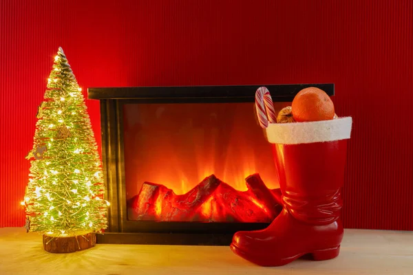 크리스마스 트리와 벽난로 근처에 있는 붉은 산타 신발. — 스톡 사진