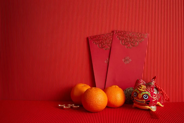 Dekorationen für das chinesische Neujahrsfest. Orange, rotes Päckchen auf rotem Hintergrund. — Stockfoto