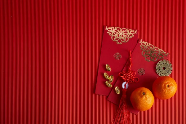 Chinese nieuwjaar festival decoraties. Oranje, rood zakje, op rode achtergrond. — Stockfoto