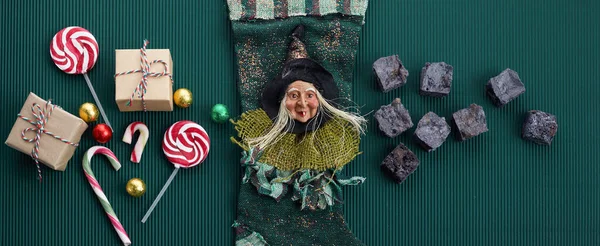 Befana sock with sweet coal and candy on dark greeen background. Italian Epiphany day tradition. — Stock Photo, Image