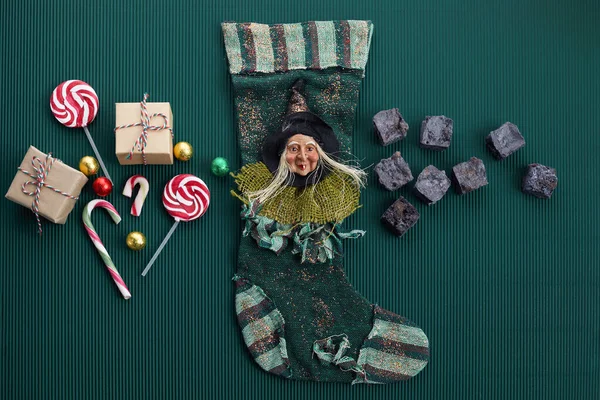 Meia Befana com carvão doce e doces no fundo verde escuro. Italiano tradição dia Epifania. — Fotografia de Stock