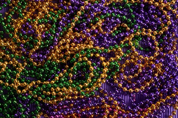 Green, gold, and purple Mardi Gras beads background — Stock Photo, Image