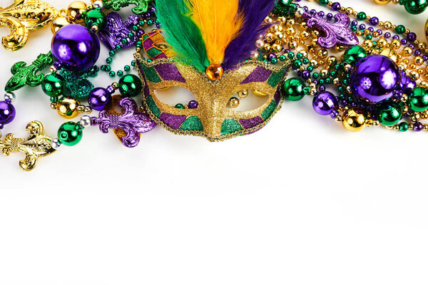 Frame of Mardi Gras mask and beads isolated on white background.