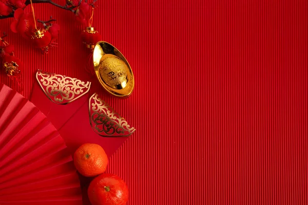 Dekorationen für das chinesische Neujahrsfest. Orange, rotes Päckchen, Pflaumenblüte und Glücksgeld auf rotem Hintergrund. Übersetzung: Lasst zehntausend Wünsche wahr werden. — Stockfoto