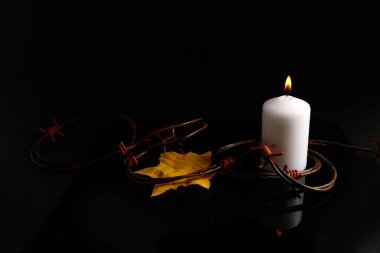 Soykırım anıları günü. Siyah arkaplanda kablo ve yanan mum