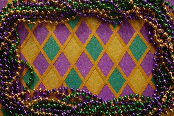 Rám z barevných Mardi Gras korálků na diamantovém pozadí — Stock fotografie