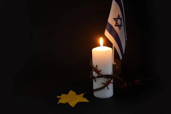 День пам'яті жертв Голокосту. Колючий дріт і вогняна свічка на чорному фоні. — стокове фото