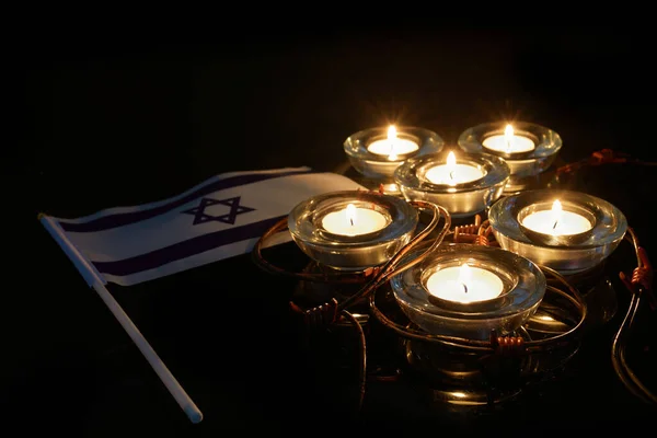 Καμένο κερί και σημαία του Ισραήλ σε μαύρο φόντο. Ημέρα μνήμης Ολοκαυτώματος — Φωτογραφία Αρχείου