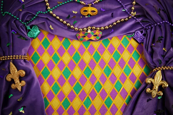 Frame of Mardi Gras Mask and colorful Mardi Gras Beads on diamond shaped background — Stock fotografie