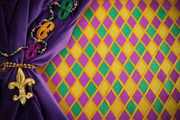 Frame of Mardi Gras Mask and colorful Mardi Gras Beads on diamond shaped background — Stock fotografie