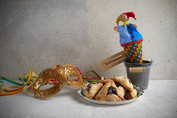 Jüdischer Feiertag Purim-Hintergrund mit Hamam oder Haman-Ohren-Keksen, Karnevalsmaske und Krachmacher — Stockfoto