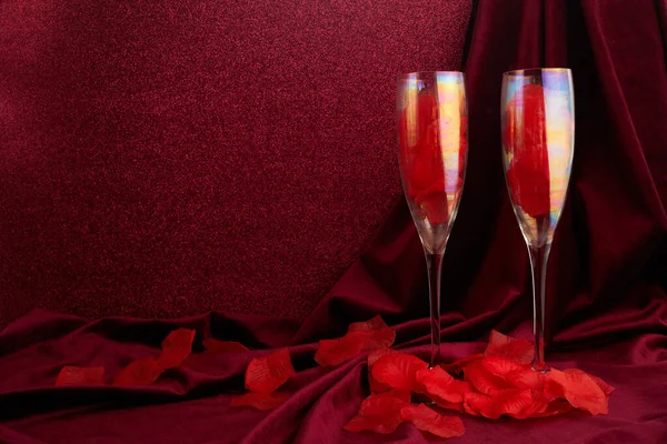 Sevgililer Günü arkaplanı şampanya bardakları ve kırmızı kurdeleli koyu kırmızı arka plan — Stok fotoğraf