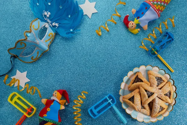 Židovská dovolená Purim pozadí s hamantaschen nebo hamans uši cookies, karneval maska a hluk — Stock fotografie