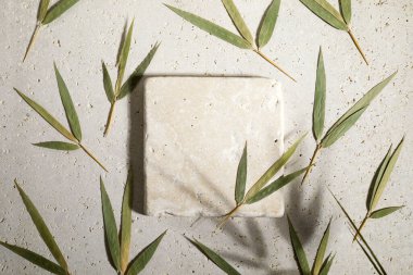 Travertine taşı biege arkaplanı ve bambu yaprakları üzerinde düz bir podyum uzanıyordu. Ürün tanıtımı Güzellik kozmetik vitrini.