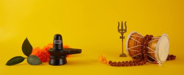 Mutlu Maha Shivaratri tebrik kartı - Shiva Linga çiçeklerle süslenmiş, trishula, damru ve bilva yapraklarıyla. Hindu festivali Shiva Lord 'u kutladı