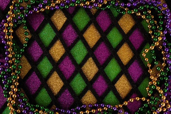 Frame of Mardi Gras Mask and colorful Mardi Gras Beads on diamond shaped background — Stock fotografie