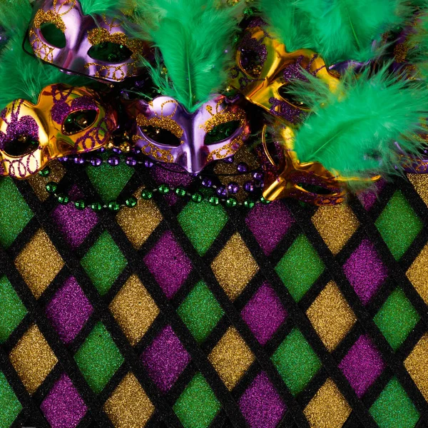 Frame of Mardi Gras Mask and colorful Mardi Gras Beads on diamond shaped background — Stock fotografie