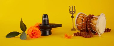 Mutlu Maha Shivaratri tebrik kartı - Shiva Linga çiçeklerle süslenmiş, trishula, damru ve bilva yapraklarıyla. Hindu festivali Shiva Lord 'u kutladı