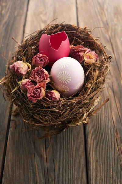 Húsvéti tojás, száraz rózsák egy fafészekben. A minimális koncepció. — Stock Fotó