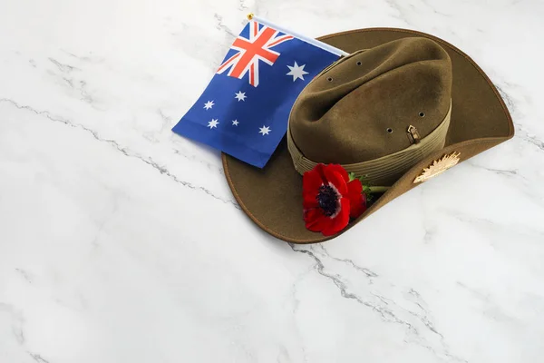 Anzac army slouch hat with Australian Flag and Poppy on stone background — Stock Photo, Image