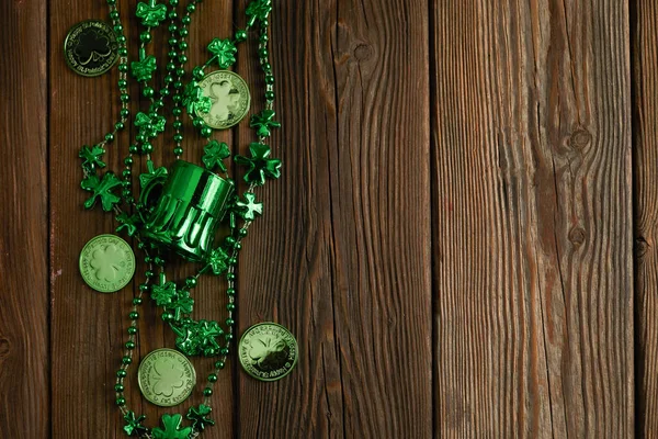 St Patricks Den hranice shamrocks korálky a mince přes rustikální dřevo pozadí — Stock fotografie