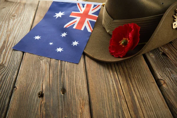 Anzac armé slouch hatt med australisk flagga och vallmo på trä bakgrund — Stockfoto