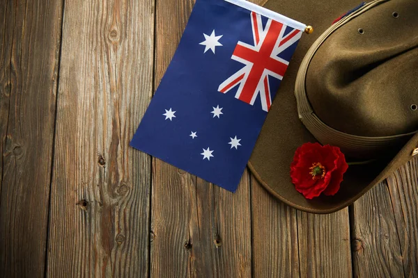 Anzac army slouch hat with Australian Flag and Poppy on wooden background — Stock Photo, Image